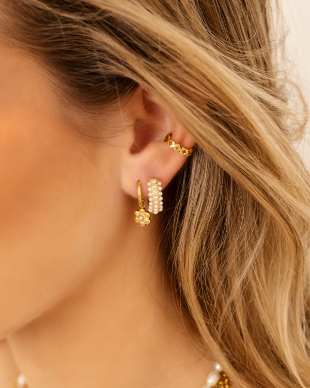 Model draagt gouden earparty met parels