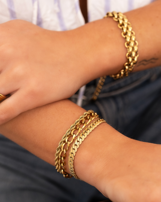 Model draagt gouden armparty met schakels