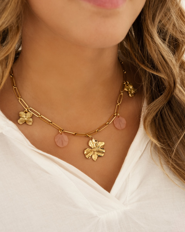 Model draagt gouden en roze ketting