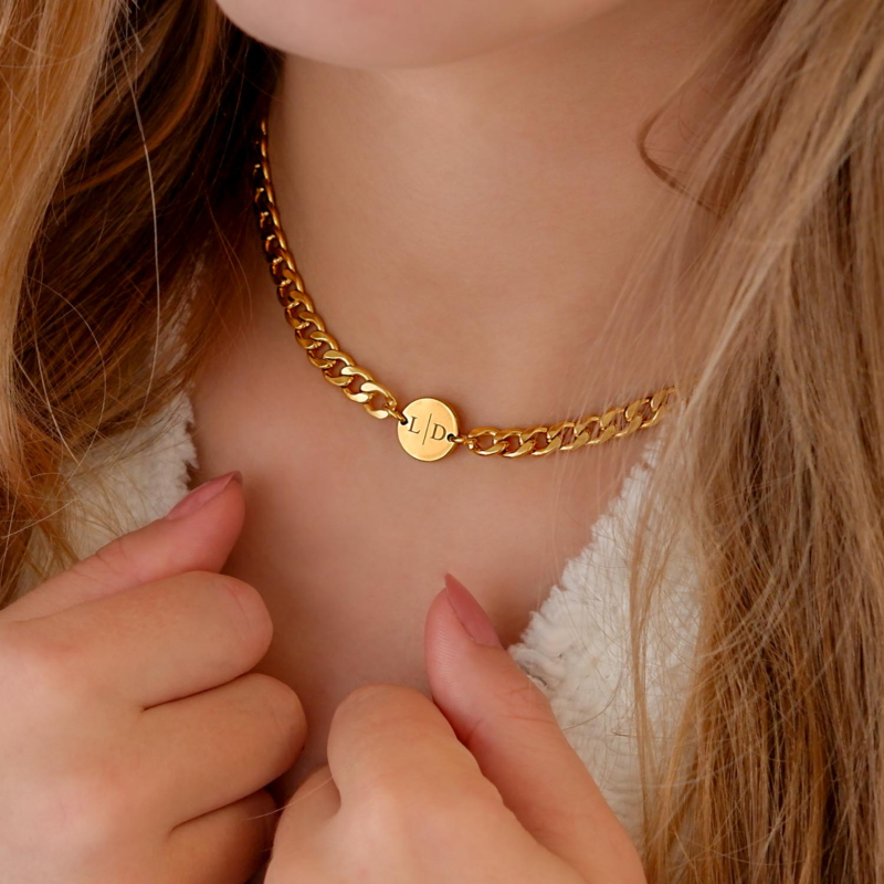 Gouden chunky initialen ketting bij blond haar