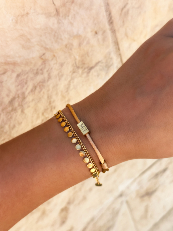 Model draagt gouden armbanden set