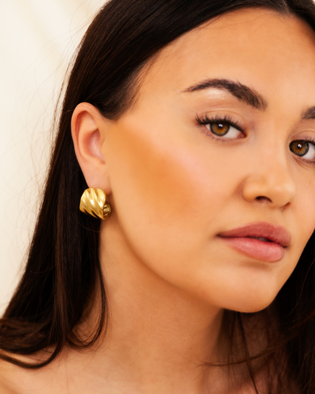 Model draagt gouden bold earrings