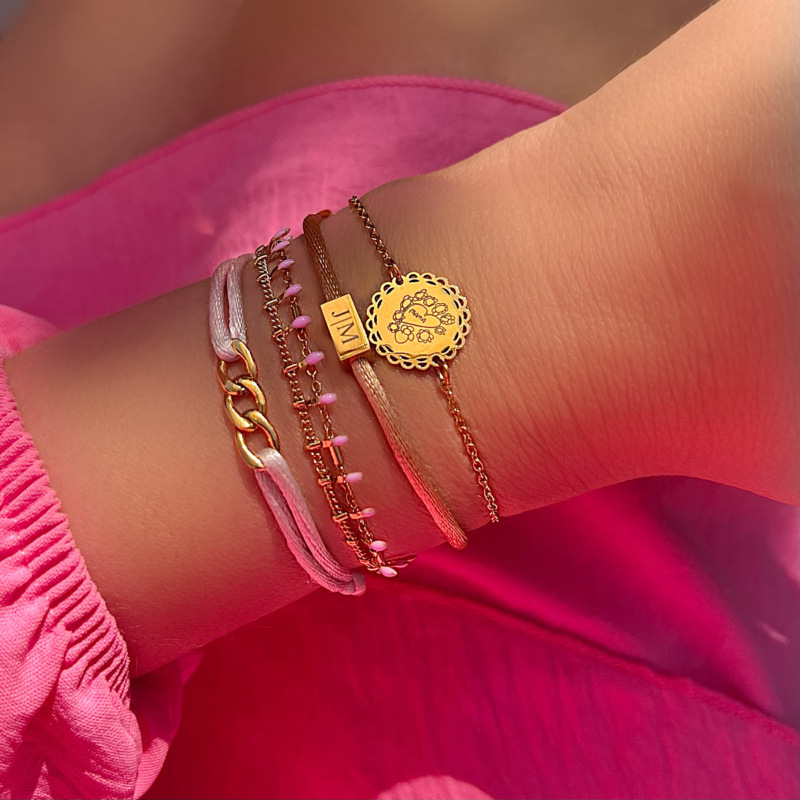 Mix van gouden en roze armbanden