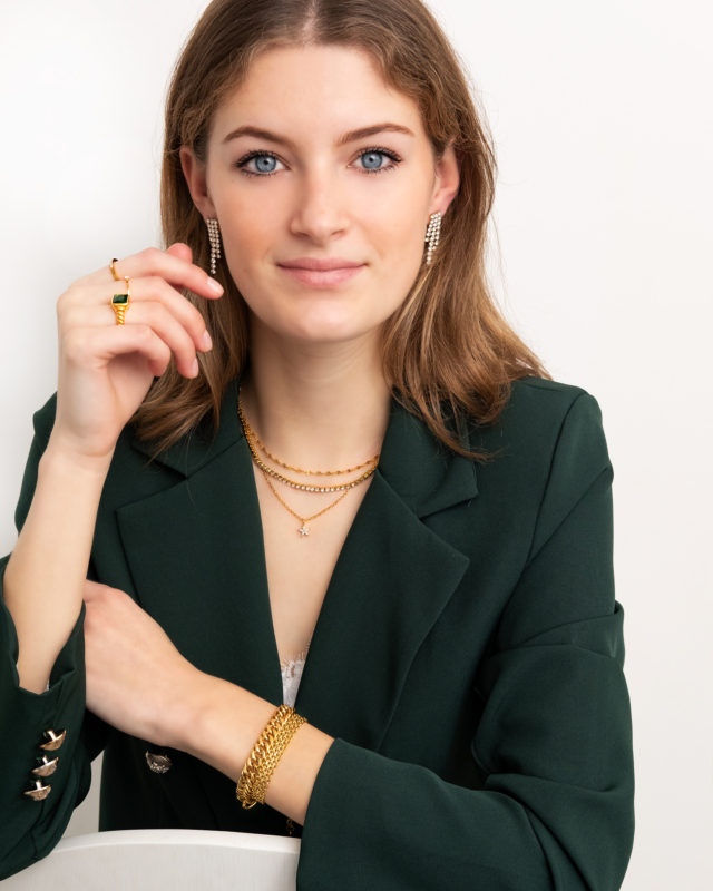 gouden sieraden bij vrouw met groene blazer