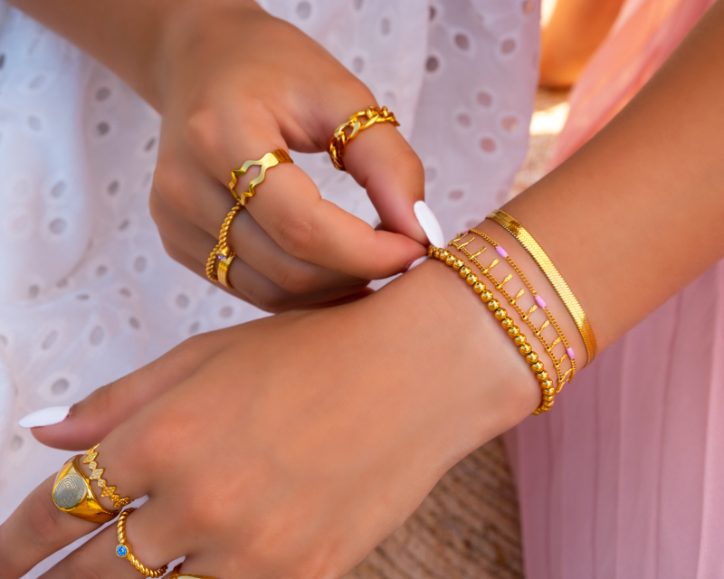 Handen met gouden armbandjes en ringen