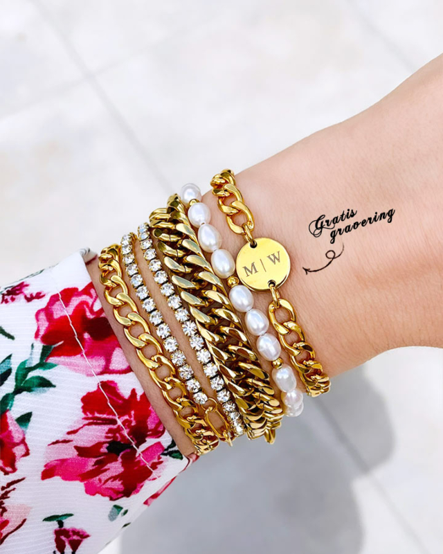 Gouden chunky initial armband om pols bij vrouw