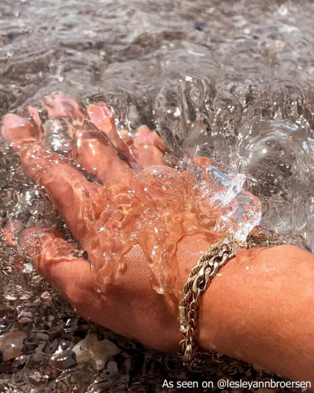 Influencer draagt gouden schakelarmband in water