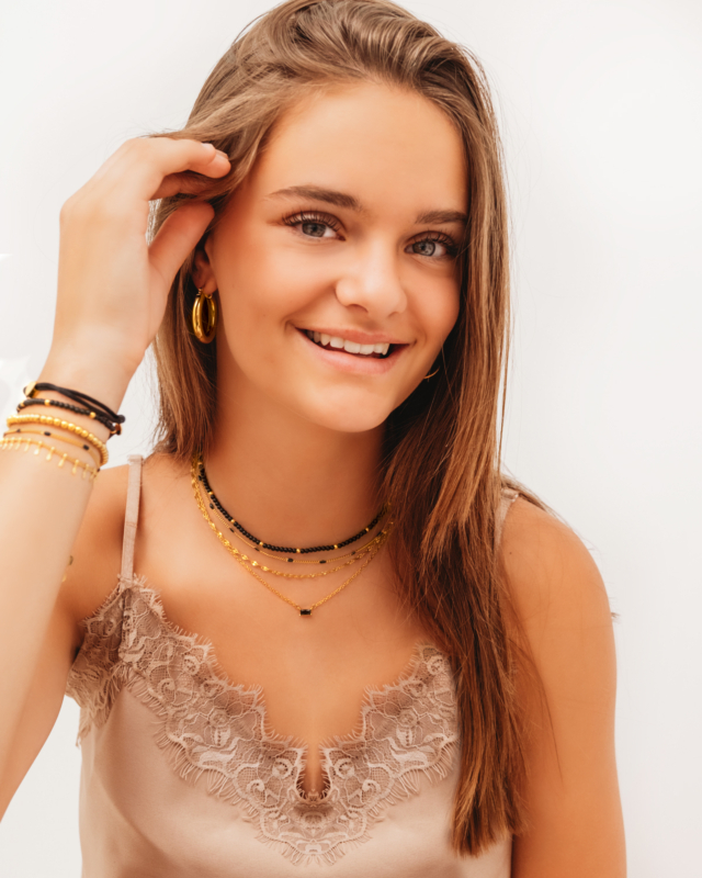 Model draagt mix van gouden sieraden