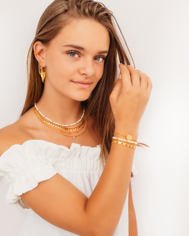 Model draagt mix van gouden sieraden