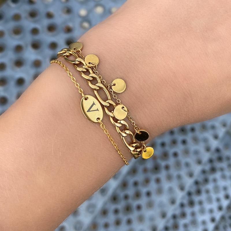 Vrouw draagt leuke mix van gouden armbandjes om de pols