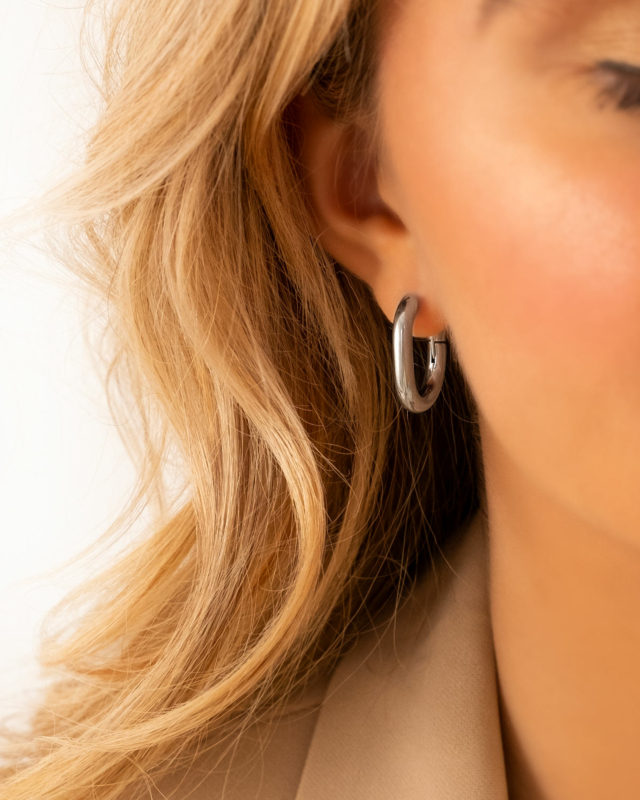 Model draagt Chunky oval hoop earrings in oor