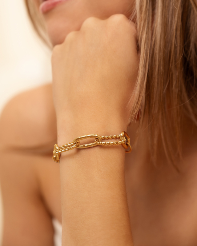 Gouden schakelarmband gedraaid bij model