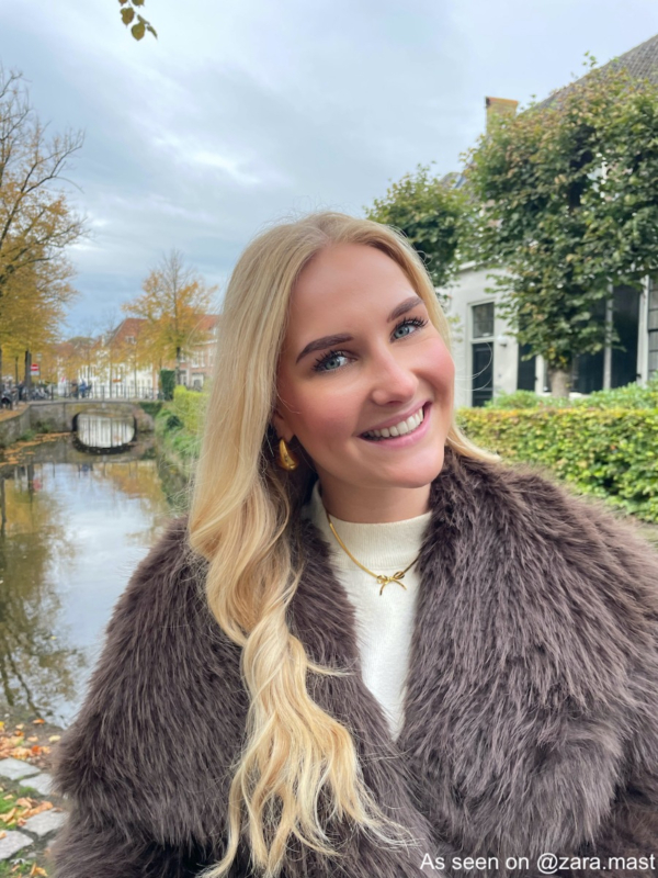 Influencer draagt gouden ketting met strikje