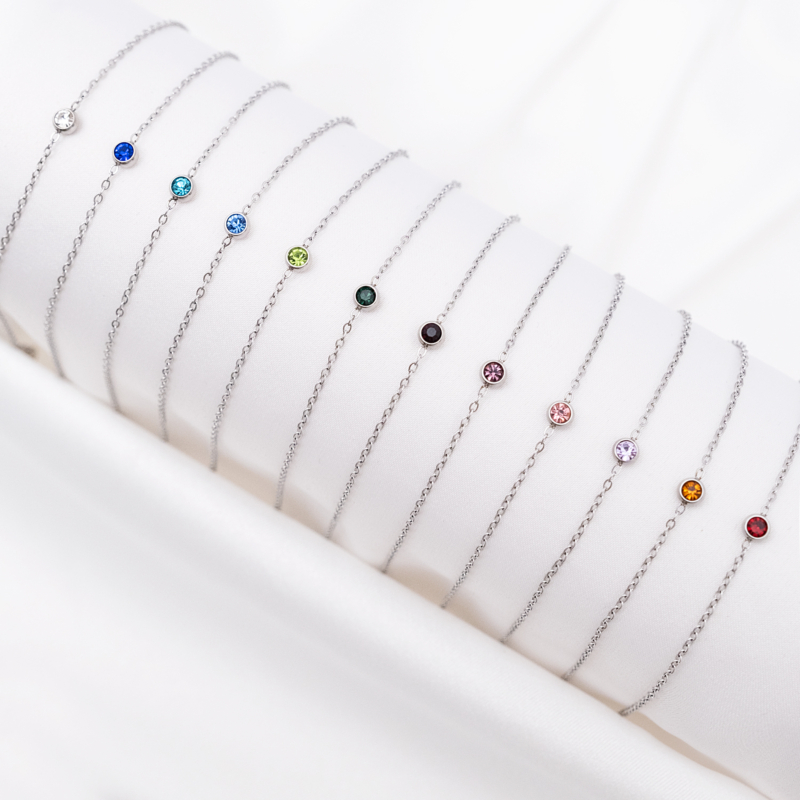 Zilveren birthstone armbandjes op witte ondergrond