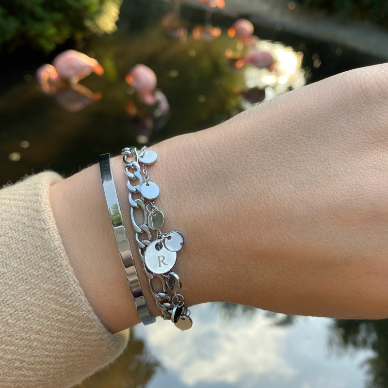 Vrouw draagt muntjes armband om de pols voor een complete look! 