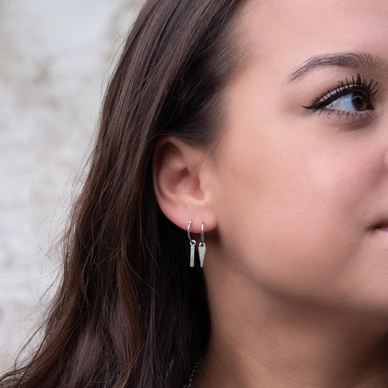 Vrouw draagt sterling zilver oorringetjes met een hanger