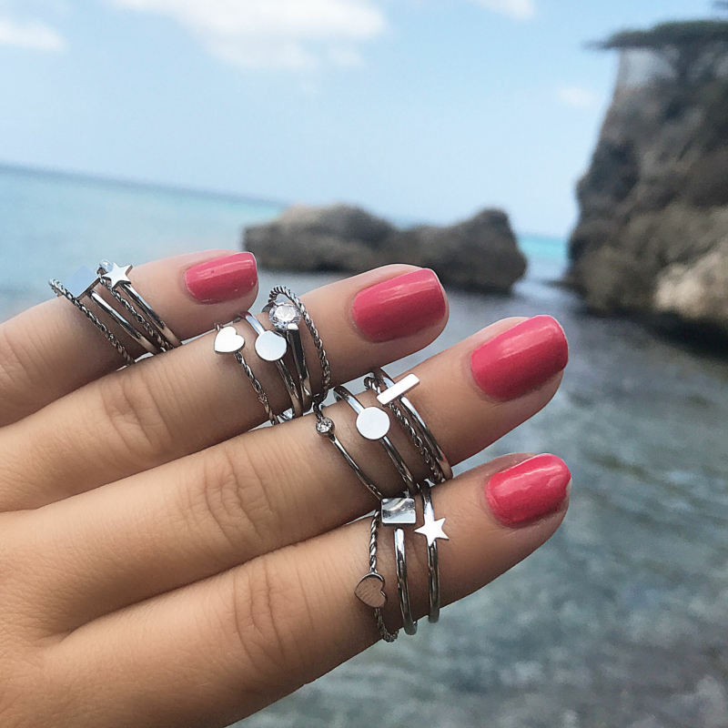 mooie zilveren ringen om de hand met roze nagellak