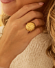 Gouden ovale ring met streepjes bij model