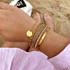 Mooie gouden armparty met roze tennis armbandje