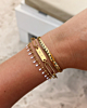 Model draagt gouden armbanden mix