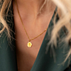 gouden ketting met initial en shiny steentje om nek