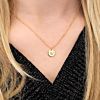 Gouden ketting met letter samen met een roze top