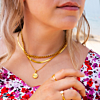 Model draagt gouden necklace layer met gepersonaliseerde ketting