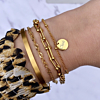 Gouden armparty mix om pols bij vrouw