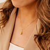 Model draagt gouden ketting met teardrop hanger