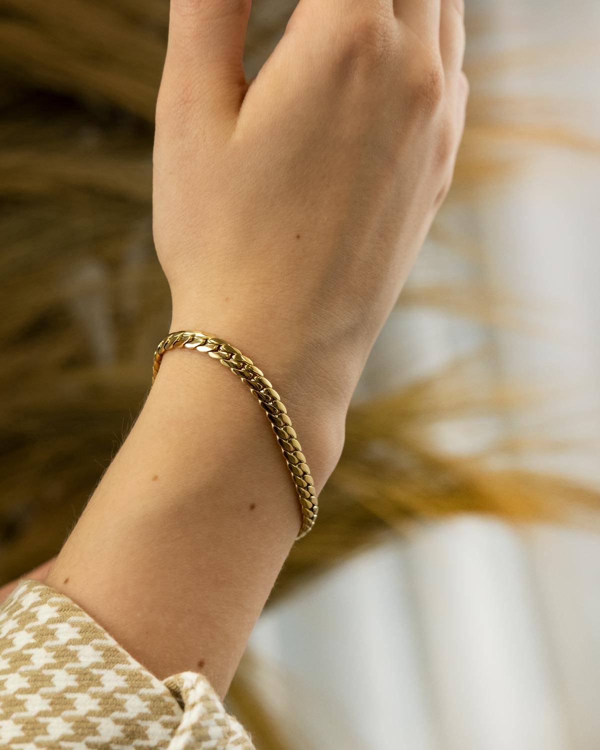 gouden platte chain armband om pols