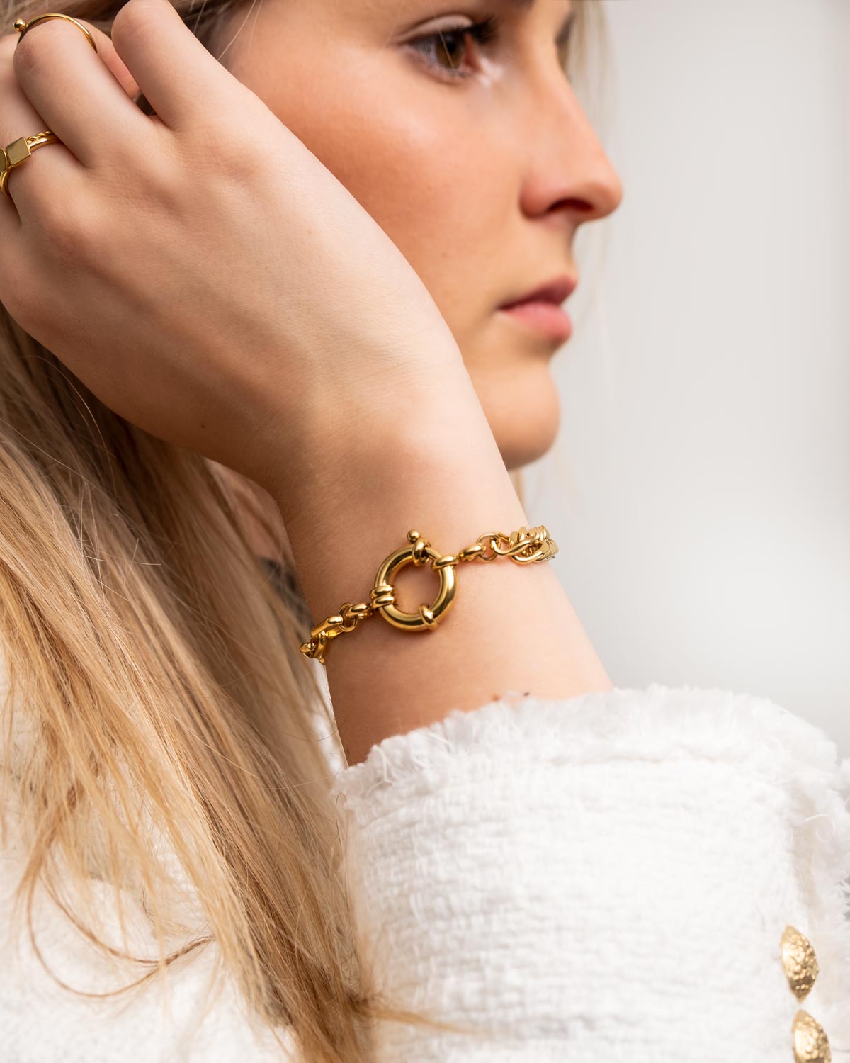 vrouw draagt gouden schakelarmband met kapittelslot