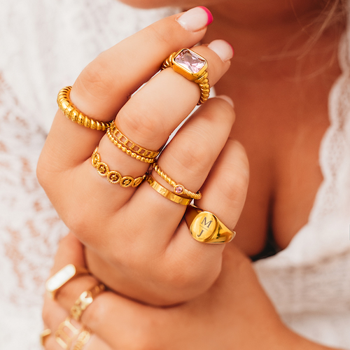 Een vrouwen hand met 8 gouden ringen